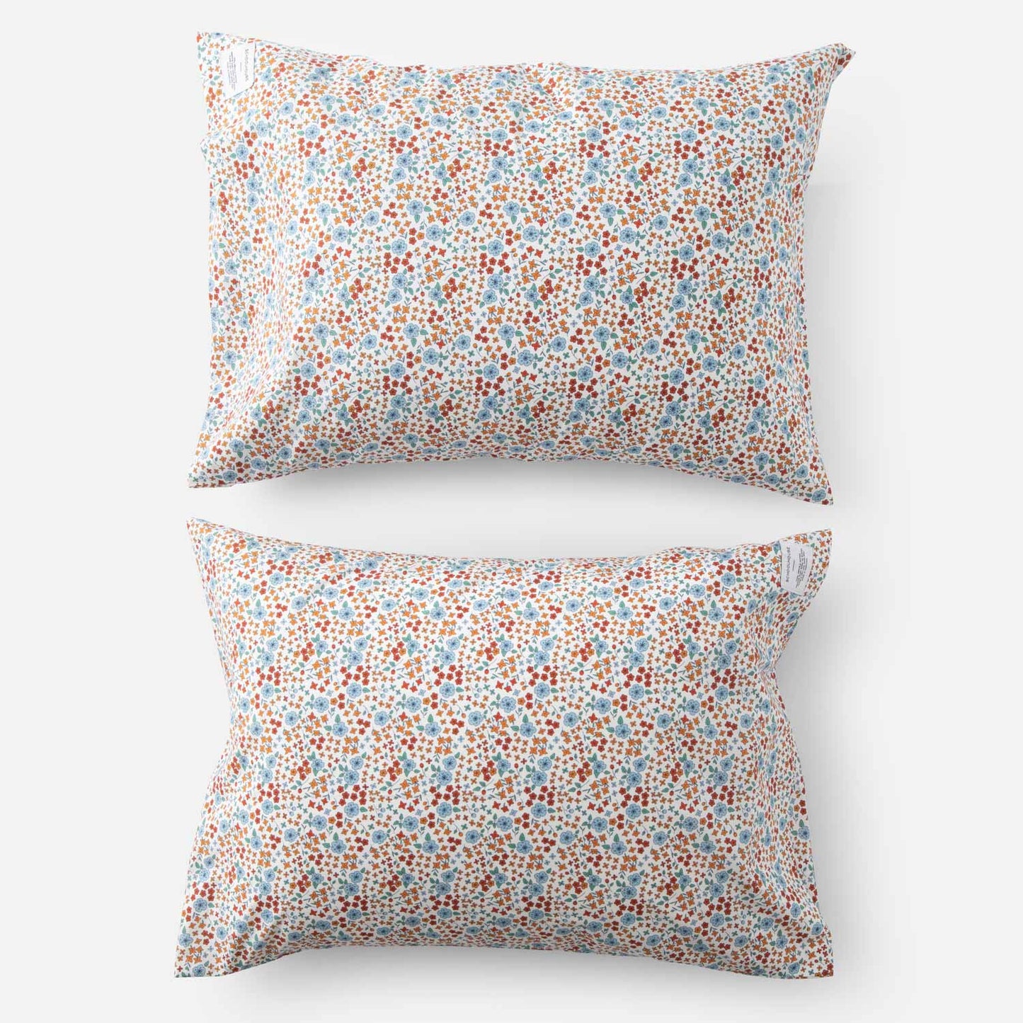 Top-down view of two Wallowa floral percale pillowcases showcasing small multicolor floral print on white studio background