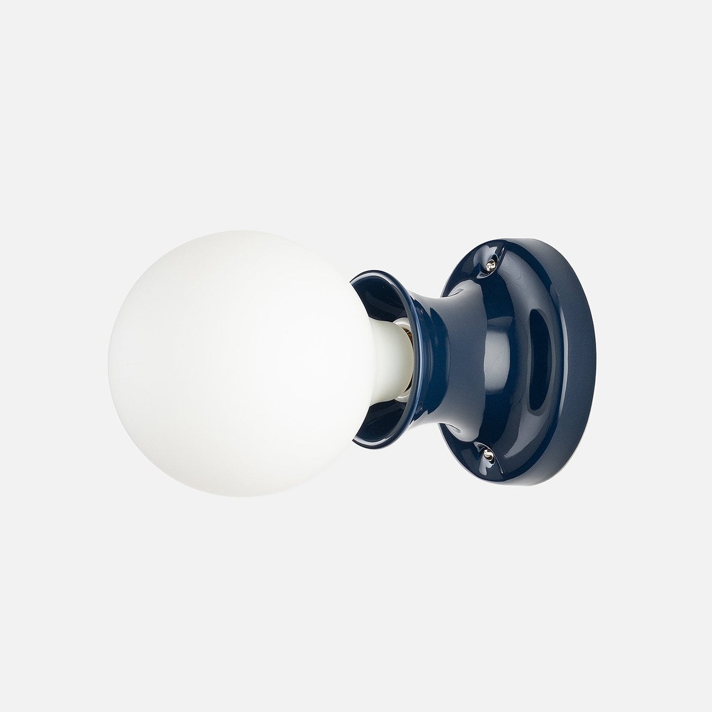 Side view of Alabax small flush mount showing white glass globe and hand-glazed navy ceramic base