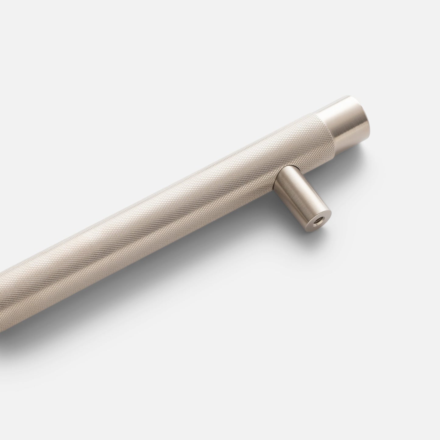 Close-up of a knurled appliance pull showcasing its textured grip and mounting post on a light background