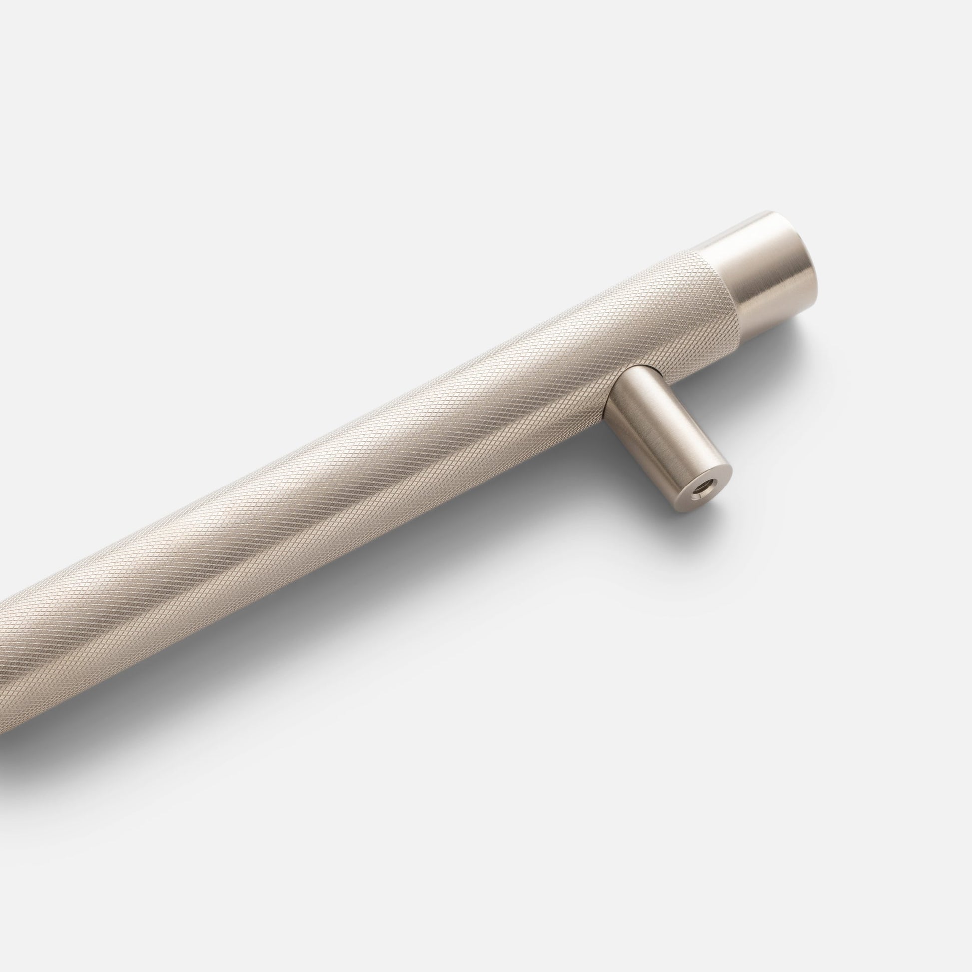 Close-up of a knurled appliance pull showcasing its textured grip and mounting post on a light background