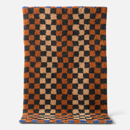 Top view of Schoolhouse x Clare V. Felix shag wool rug showing checkerboard pattern and high-pile texture on white background