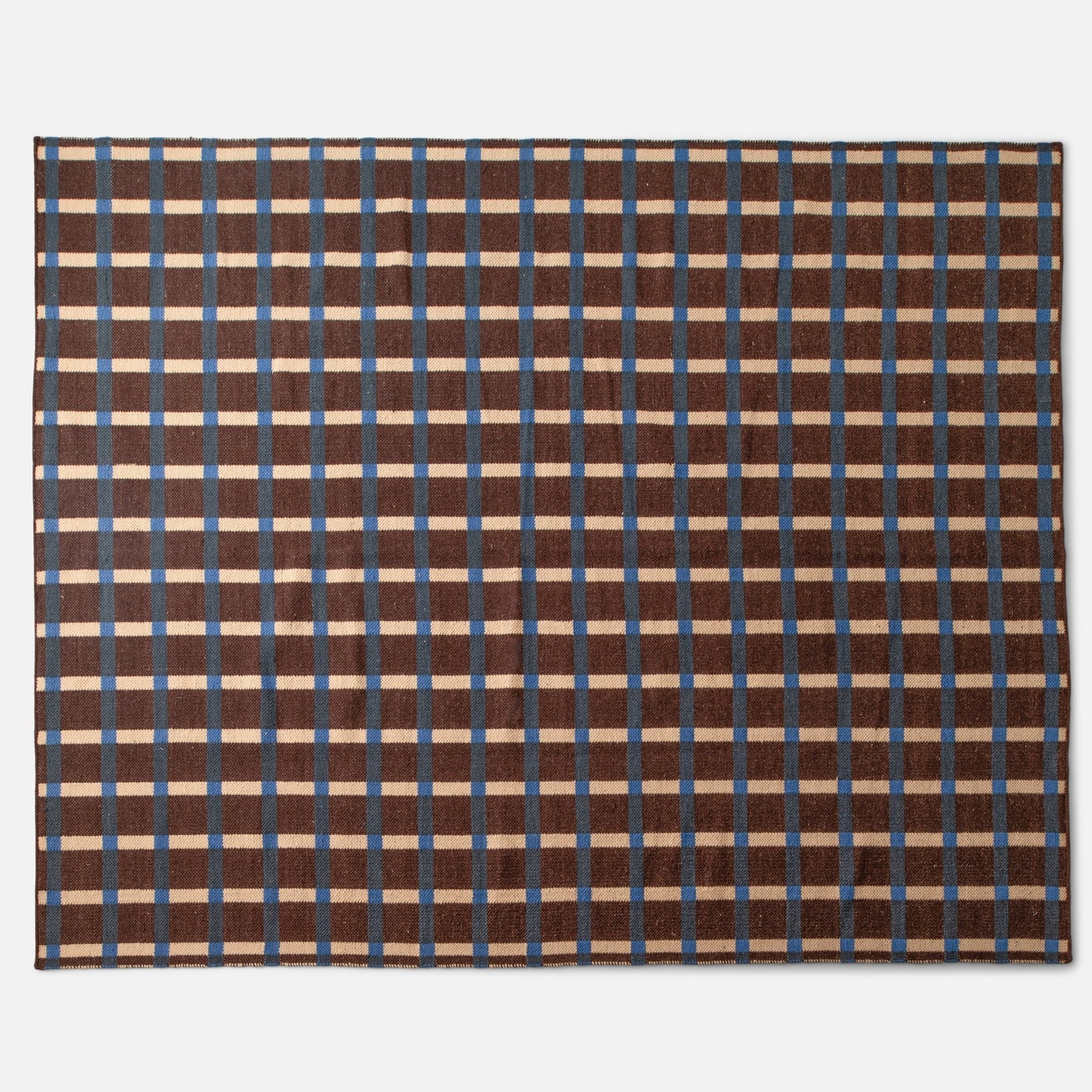 Top-down view of Plaid Wool Reversible Rug showcasing brown, blue, and cream high-contrast plaid and handwoven wool texture on a white background